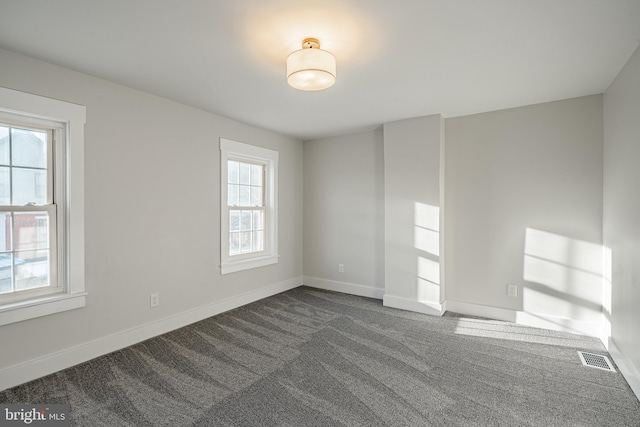 spare room featuring dark carpet