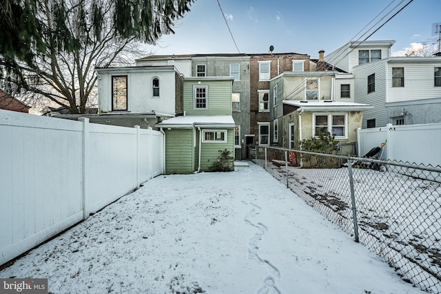 view of snow covered back of property