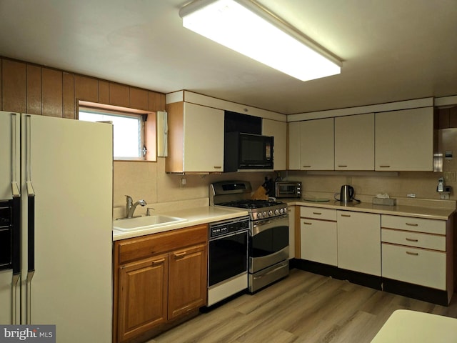 kitchen with sink, light wood-type flooring, and black appliances