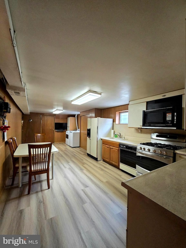 kitchen featuring light wood-type flooring, sink, and black appliances