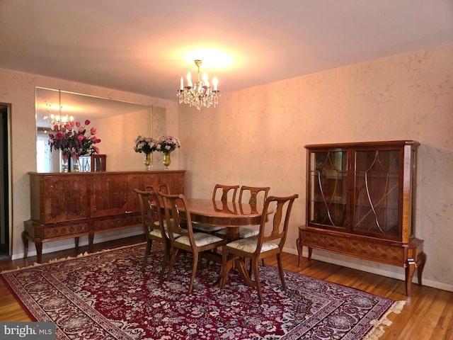 dining room with hardwood / wood-style flooring and a chandelier