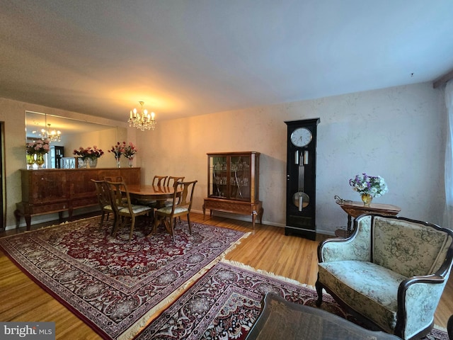 dining area with hardwood / wood-style floors and a chandelier