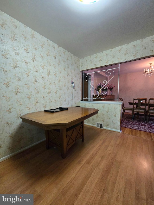 unfurnished dining area with hardwood / wood-style flooring and a chandelier