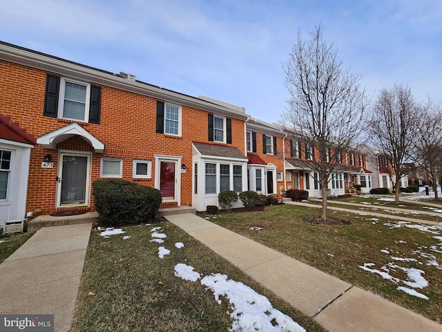 townhome / multi-family property featuring a front lawn