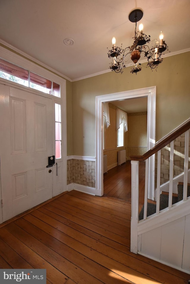 entryway featuring a chandelier, hardwood / wood-style flooring, radiator, and crown molding