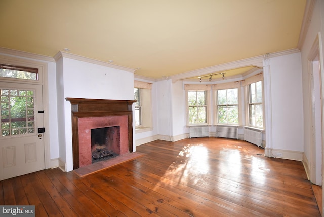 unfurnished living room featuring hardwood / wood-style floors, radiator, and ornamental molding