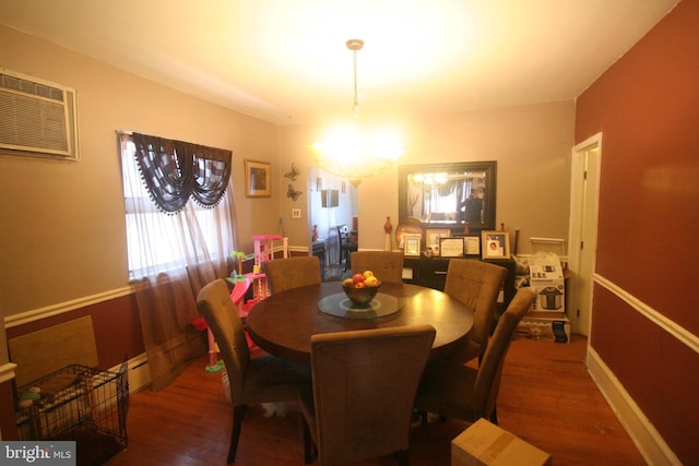 dining room featuring a chandelier, dark hardwood / wood-style floors, and a wall mounted AC