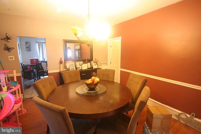 dining area featuring hardwood / wood-style flooring and an inviting chandelier