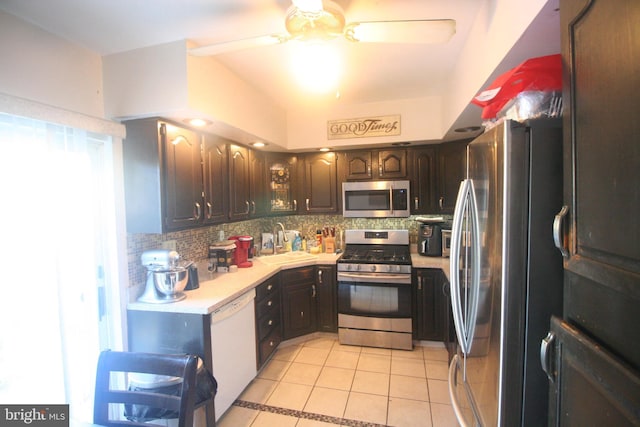 kitchen featuring decorative backsplash, sink, light tile patterned floors, and stainless steel appliances