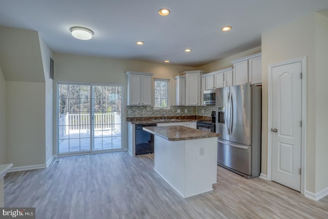 kitchen featuring a kitchen island, tasteful backsplash, appliances with stainless steel finishes, and white cabinets