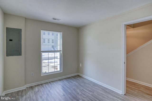 spare room featuring hardwood / wood-style flooring and electric panel