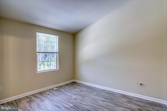 unfurnished room with dark hardwood / wood-style flooring