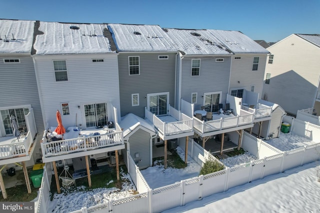 snow covered property with a deck