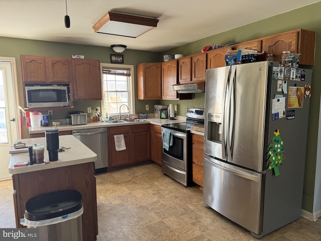 kitchen featuring appliances with stainless steel finishes, a center island, and sink