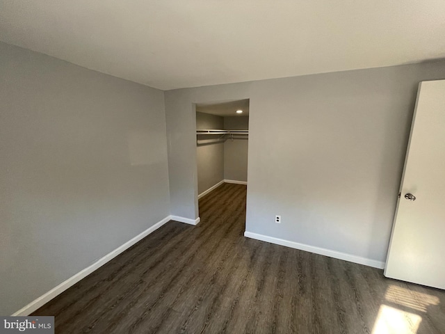 unfurnished bedroom with dark hardwood / wood-style floors and a closet