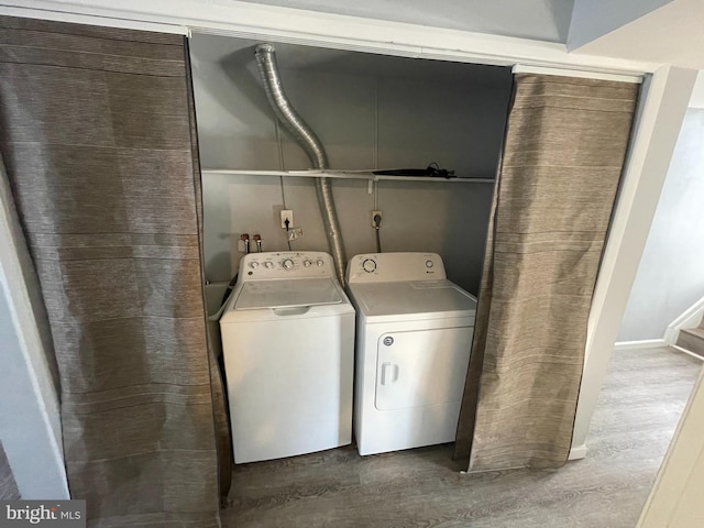 laundry room with separate washer and dryer and hardwood / wood-style floors