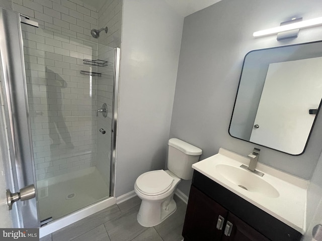 bathroom featuring vanity, toilet, tile patterned flooring, and a shower with door