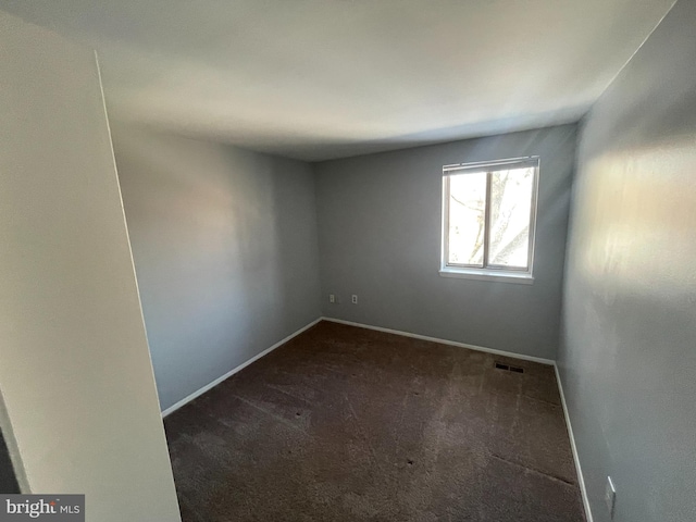 empty room featuring dark carpet