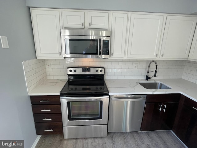 kitchen featuring tasteful backsplash, appliances with stainless steel finishes, sink, and dark brown cabinetry