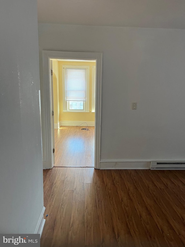 interior space featuring baseboard heating and hardwood / wood-style flooring