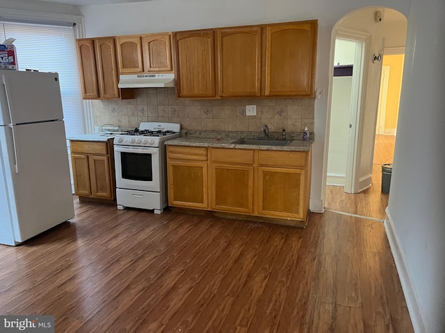 kitchen featuring sink, white appliances, tasteful backsplash, and dark hardwood / wood-style floors