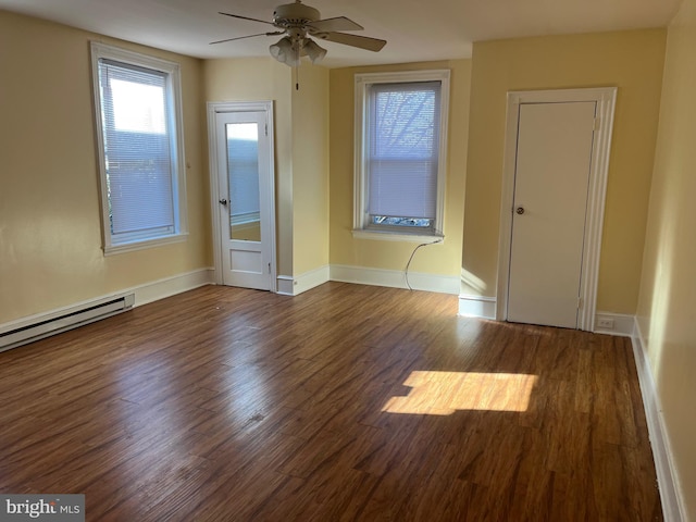 unfurnished room featuring a baseboard heating unit, ceiling fan, and dark hardwood / wood-style floors