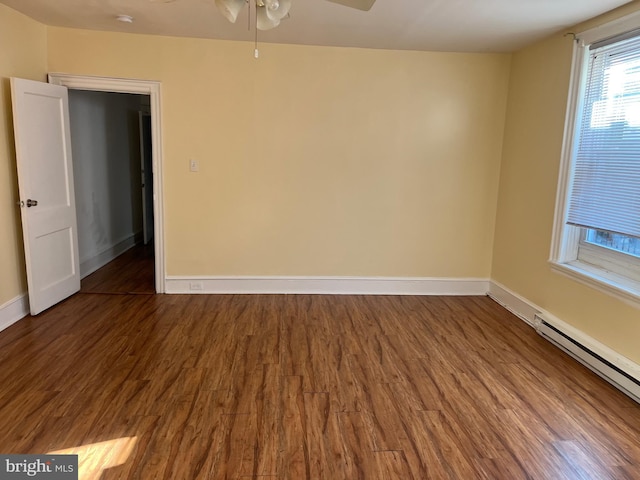 unfurnished room featuring baseboard heating, dark wood-type flooring, and ceiling fan