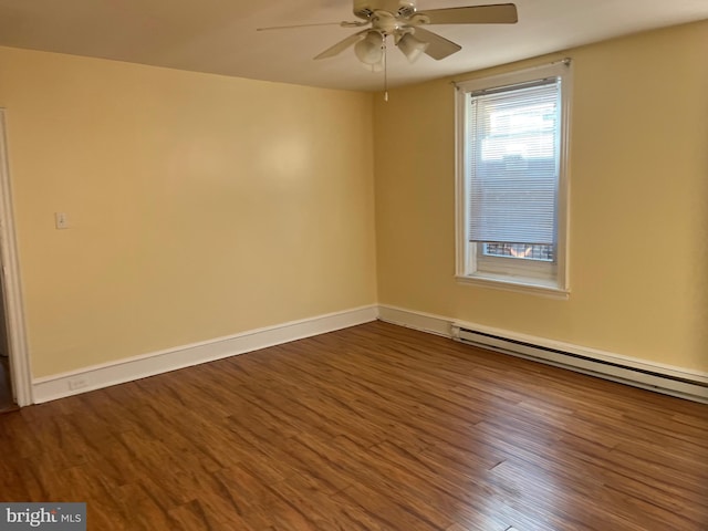 empty room with baseboard heating, ceiling fan, and dark hardwood / wood-style floors