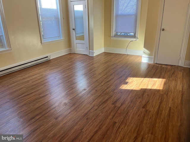 unfurnished bedroom featuring hardwood / wood-style flooring and a baseboard heating unit