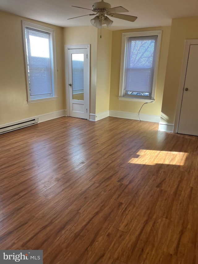 spare room featuring hardwood / wood-style floors, a baseboard heating unit, and ceiling fan