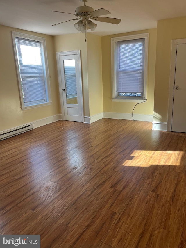 empty room featuring a baseboard heating unit, ceiling fan, and hardwood / wood-style floors