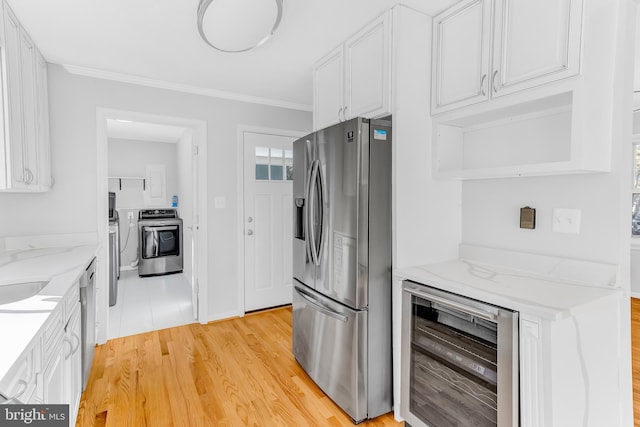 kitchen featuring wine cooler, white cabinets, washer / dryer, and stainless steel appliances