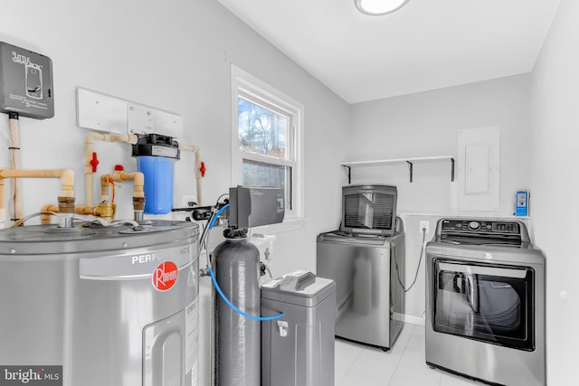 clothes washing area featuring light tile patterned floors, water heater, washer and dryer, and electric panel