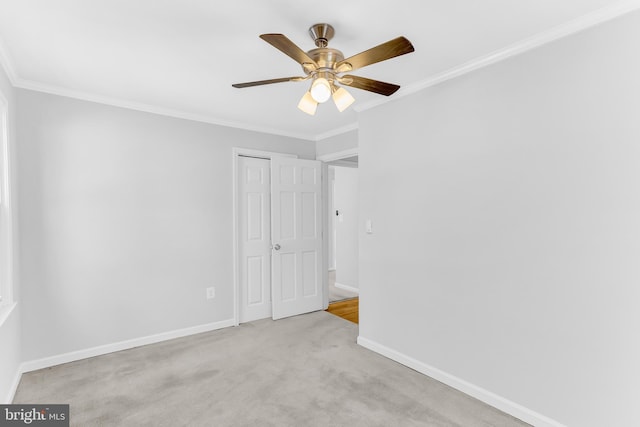 carpeted empty room featuring ceiling fan and ornamental molding