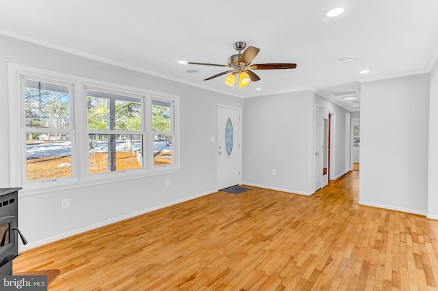 spare room with ceiling fan, crown molding, and light hardwood / wood-style flooring