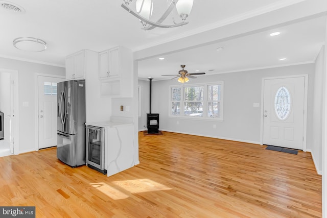 kitchen featuring stainless steel fridge with ice dispenser, light hardwood / wood-style floors, wine cooler, ornamental molding, and white cabinets