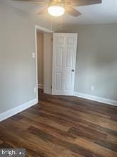 spare room with dark hardwood / wood-style floors and ceiling fan