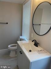 bathroom featuring hardwood / wood-style floors, vanity, and toilet