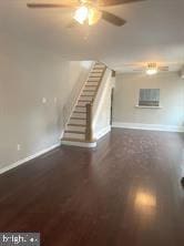 unfurnished living room with a wall mounted air conditioner and dark hardwood / wood-style floors