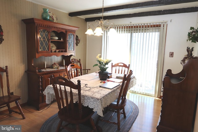 dining room with beam ceiling, light hardwood / wood-style flooring, and a chandelier