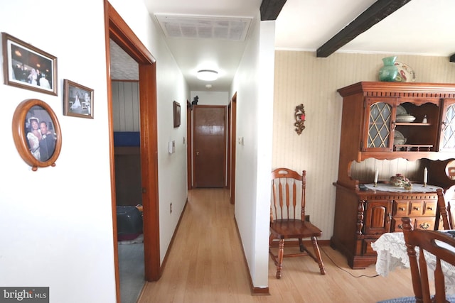 hall featuring beam ceiling and light hardwood / wood-style flooring