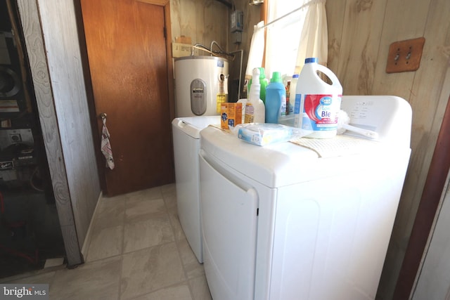 laundry room featuring electric water heater and separate washer and dryer