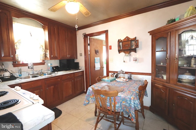 kitchen featuring crown molding, ceiling fan, light tile patterned floors, and sink