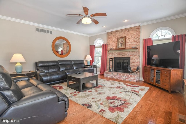 living room with crown molding, plenty of natural light, and light hardwood / wood-style flooring