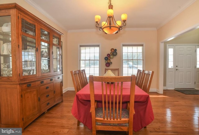 dining area featuring crown molding, light wood-type flooring, and a chandelier