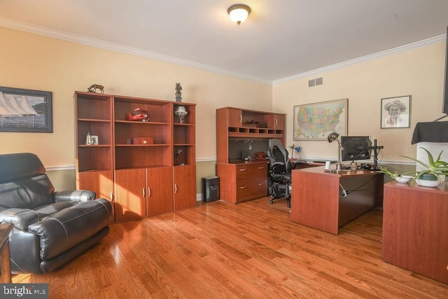 home office with light hardwood / wood-style floors and ornamental molding