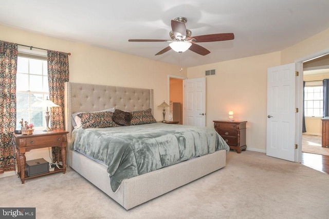 bedroom with ceiling fan and light colored carpet