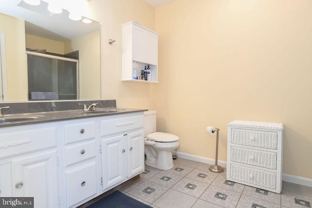 bathroom with vanity, toilet, an enclosed shower, and tile patterned flooring