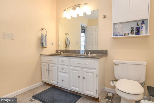 bathroom featuring toilet, tile patterned flooring, and vanity