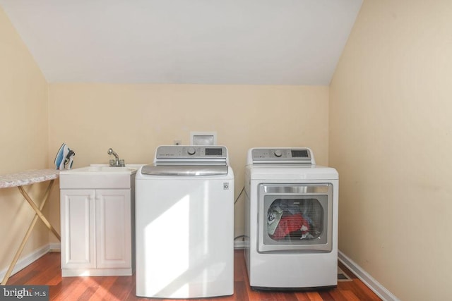 washroom featuring wood-type flooring, sink, cabinets, and washer and clothes dryer